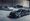 Porsche 918 Spyder, Ferrari LaFerrari, and McLaren P1 hypercars parked together in a hangar ahead of Broad Arrow's Zoute Concours Auction