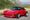 Red 1983 Porsche 911 Turbo with a Bisimoto electric conversion parked on a mountain road