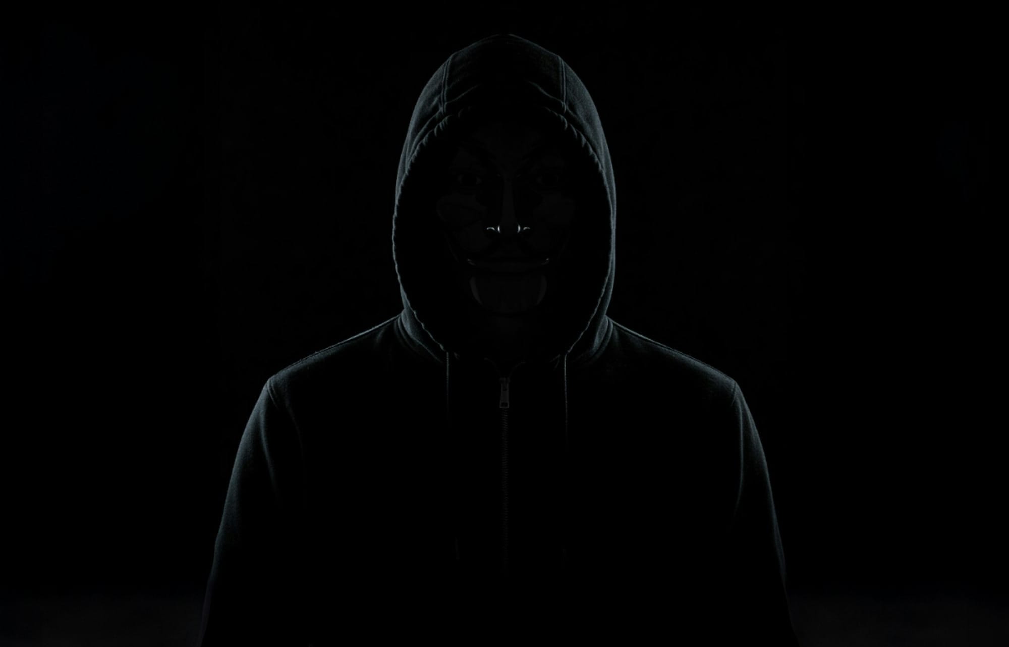 A shadowy figure in a hoodie at night