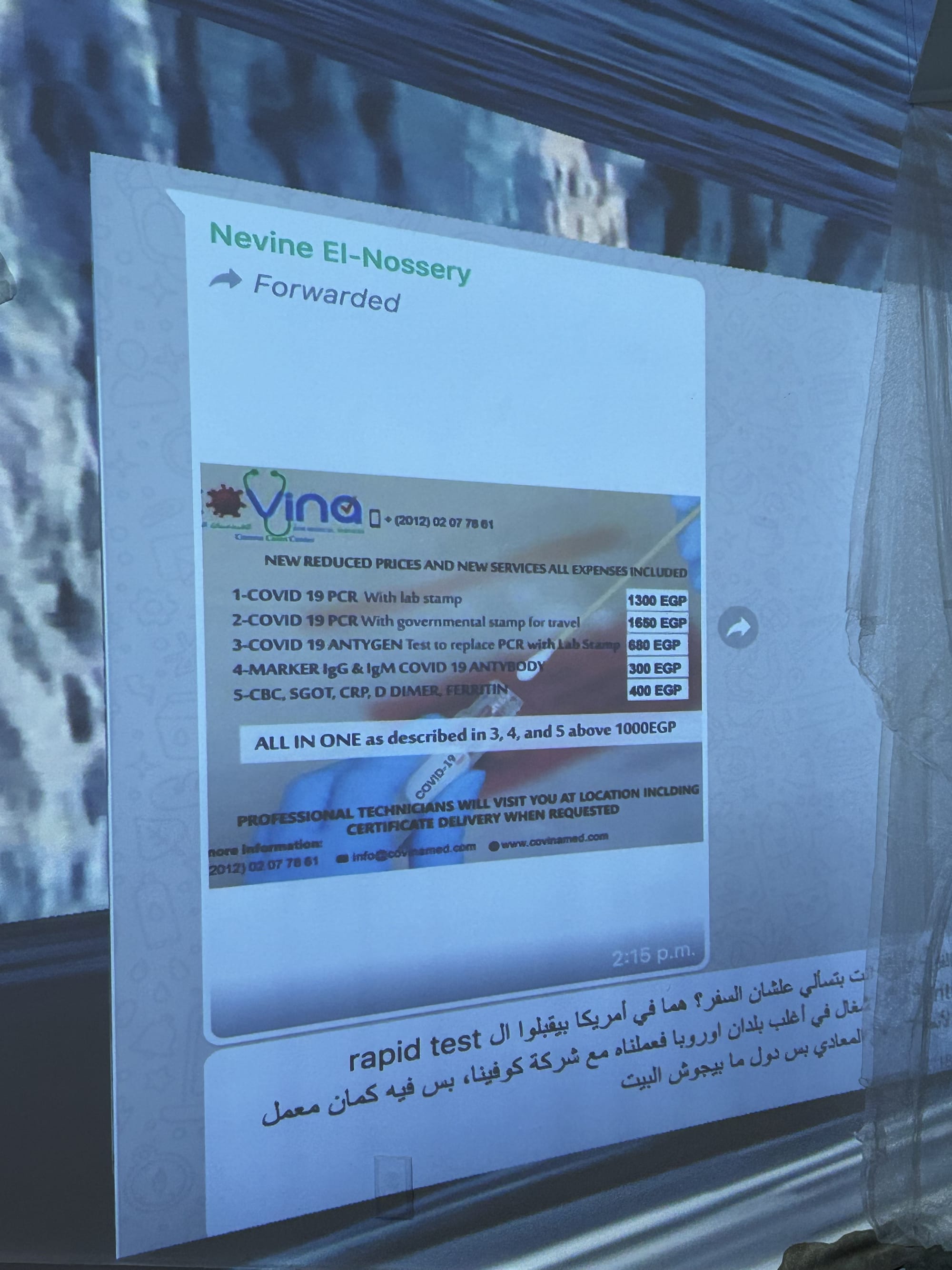 Digital projection of a screenshot of a WhatsApp group text featuring a flyer for a COVID vaccine.
