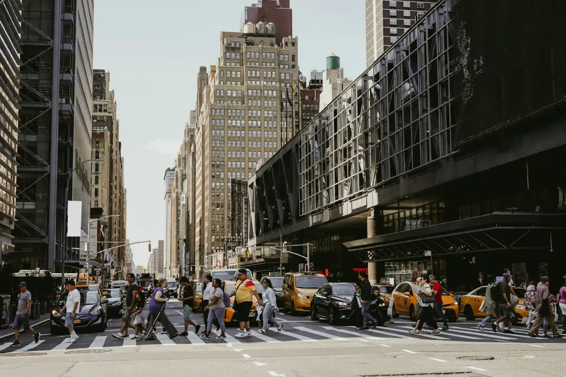 New York City crosswalk with pedestrians and yellow taxis, illustrating the pace and diversity of the US talent market for 2025 employer branding.