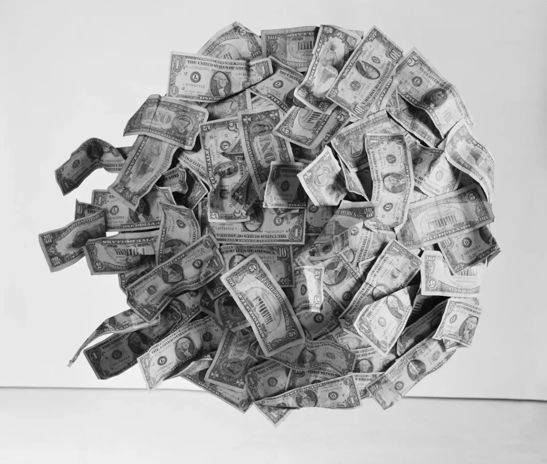 Black and white photo of a floating sphere made of US dollar bills, illustrating the hidden cost of the skills promise in an EVP.