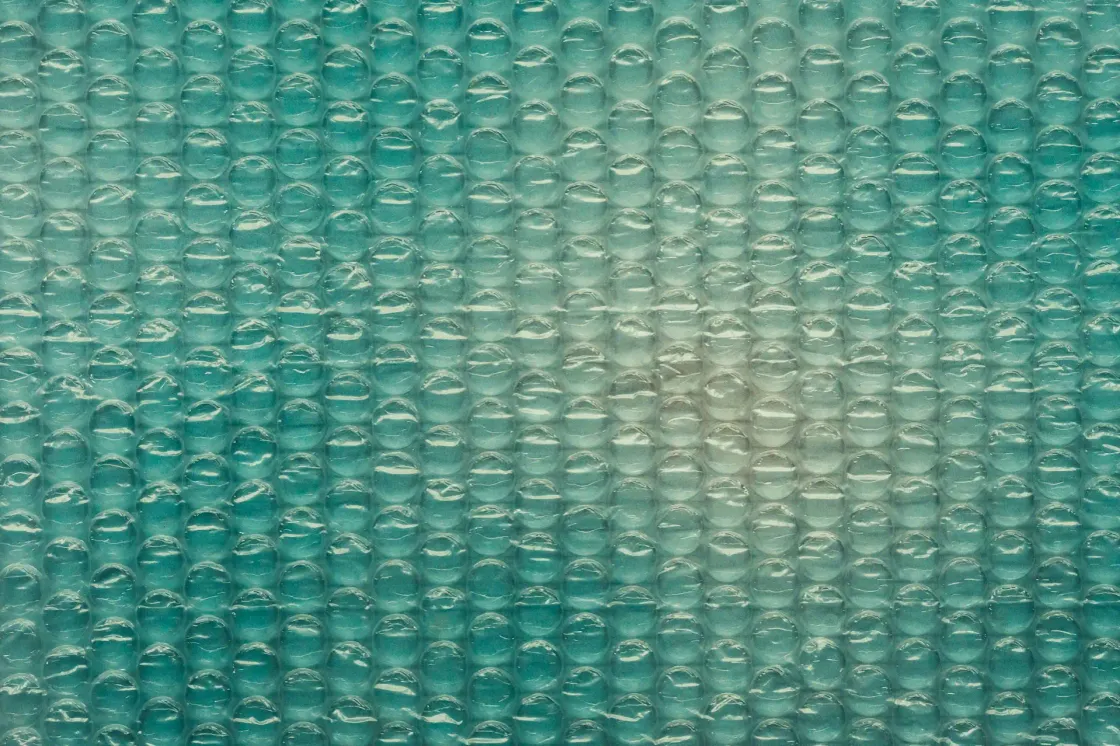 Close up of teal bubble wrap texture representing protection and stability in a fast changing, AI driven workplace.
