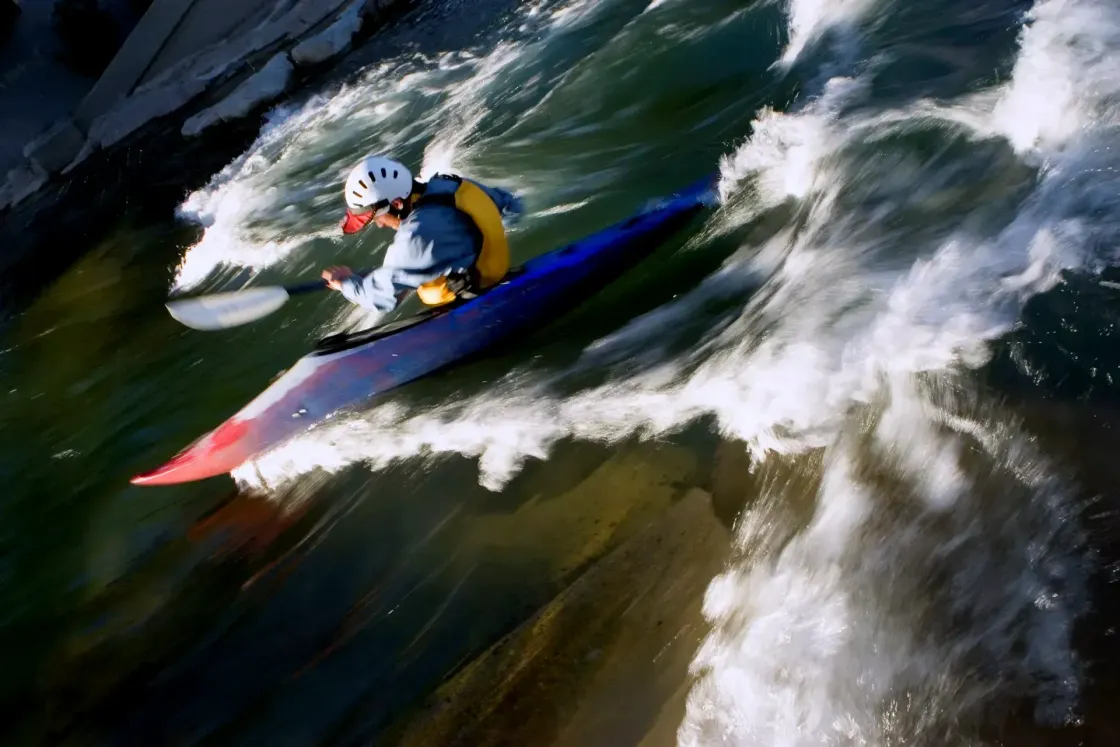 Senior engineer burnout in AI-forward organisations, illustrated by a kayaker paddling hard against fast-moving whitewater rapids.
