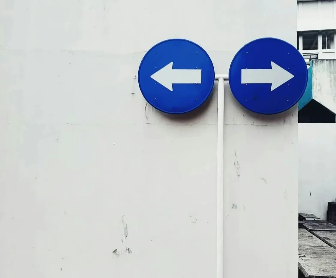 Opposing direction signs representing contrasting approaches to employee trust at Nintendo and BlackRock.