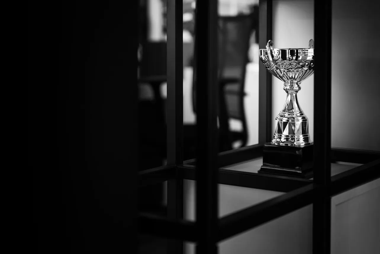 Polished trophy on display in a corporate office, symbolic of the hollow recognition many companies pay for rather than earn.