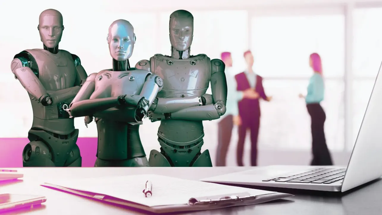 Three humanoid robots stand in an office, with blurred human colleagues in the background, symbolizing consulting being reshaped by AI while employees play defense.