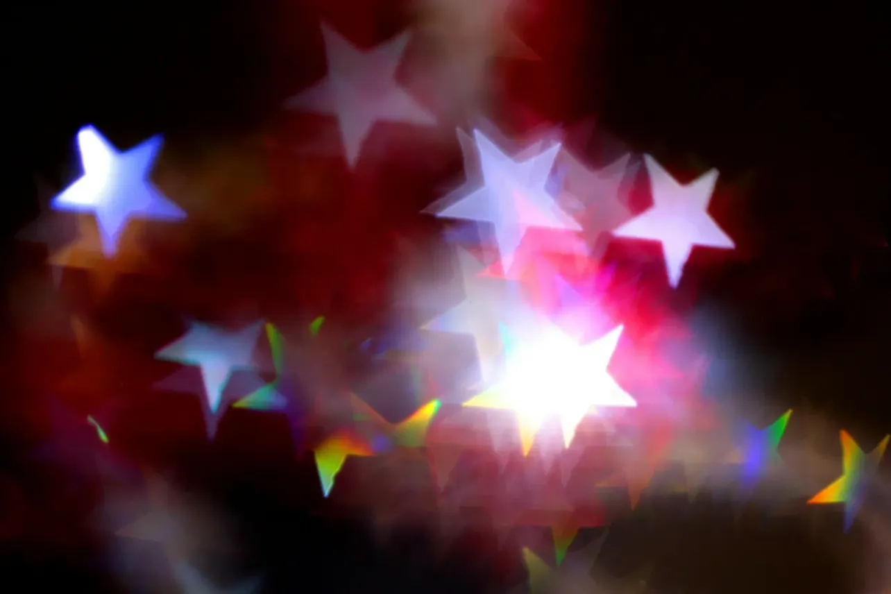 Out-of-focus star-shaped bokeh in red and white, representing employer review site ratings and reputation.