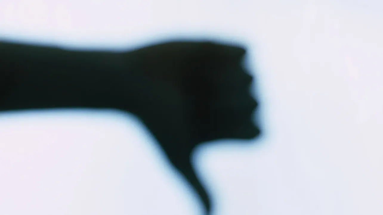 A blurred silhouette of a clenched fist against a pale background, suggesting tension, impact, and a sudden shift in workplace mood.