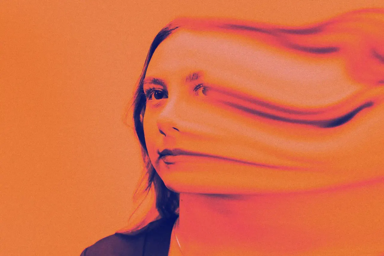 A woman's portrait smeared sideways into streaks of orange and red, her face dissolving into motion blur.