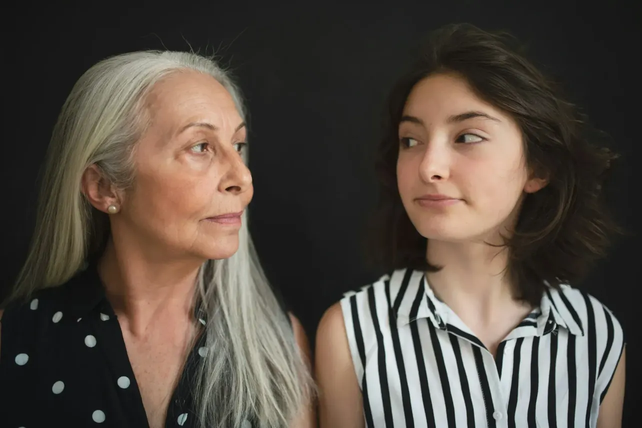 Older and younger women looking at each other, illustrating age bias in hiring and the challenges facing both early-career and experienced workers.