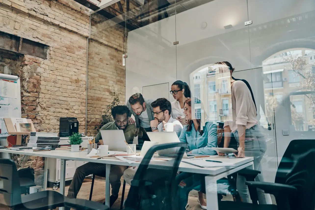 Team collaborating in a modern workplace as recruitment faces growing questions over AI, transparency and candidate trust.