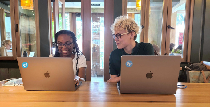 Image of Sabine and g working together in a cafe