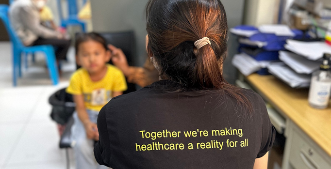 Photo of Srey Mouy, our Watsi rep from CSC's ENT Department, checking on Vanniza after her surgery.