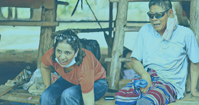 Image of Sonam sitting with a Watsi patient who received cataract surgery with the help of Watsi supporters