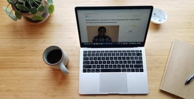 An Image of a laptop, coffee, pen, plant and a diary.