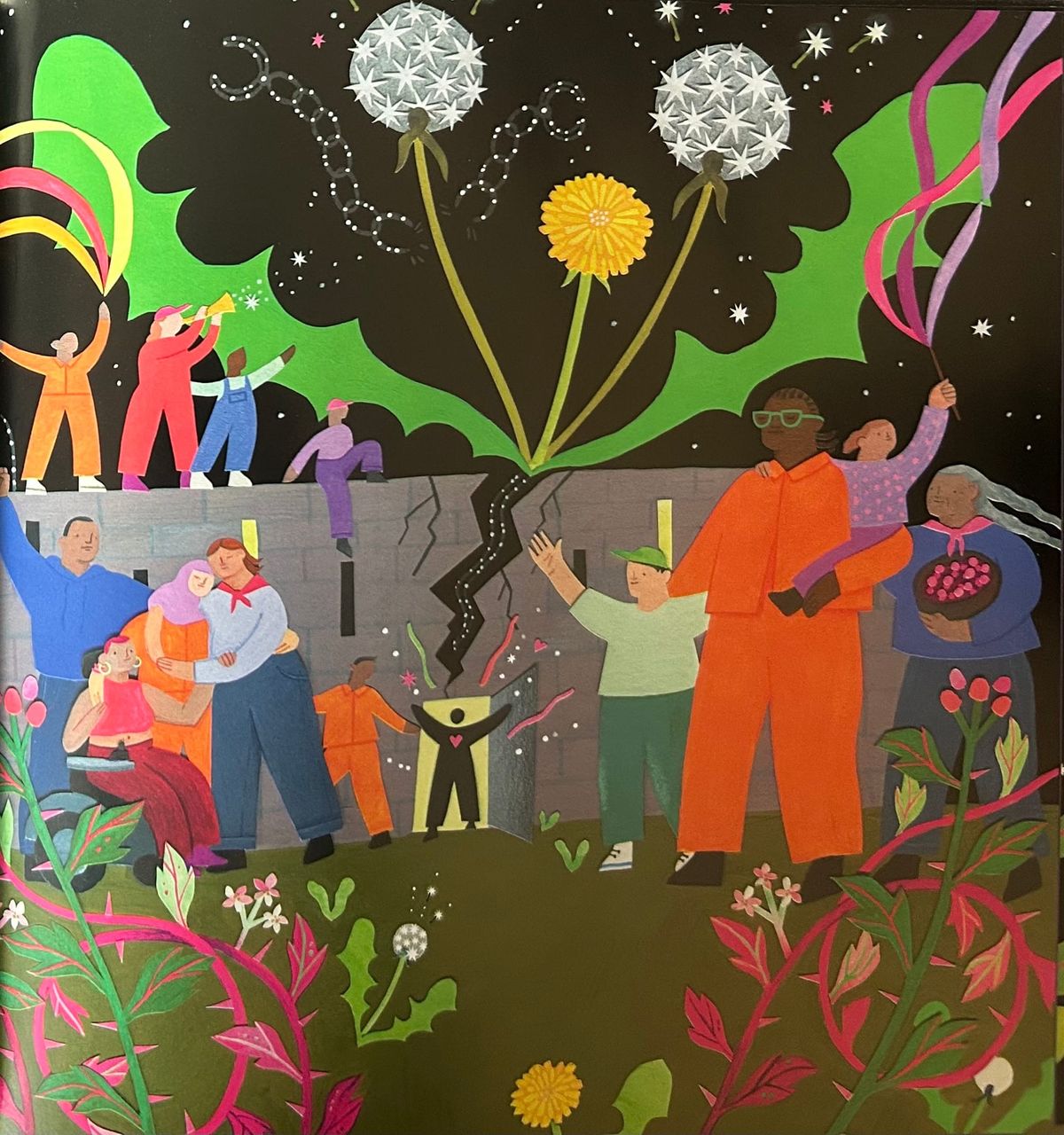 A prison wall cracks open as people of all ages smile, hold hands, hug, and play music. Dandelions and other colorful plants and vines overgrow the gray prison walls.