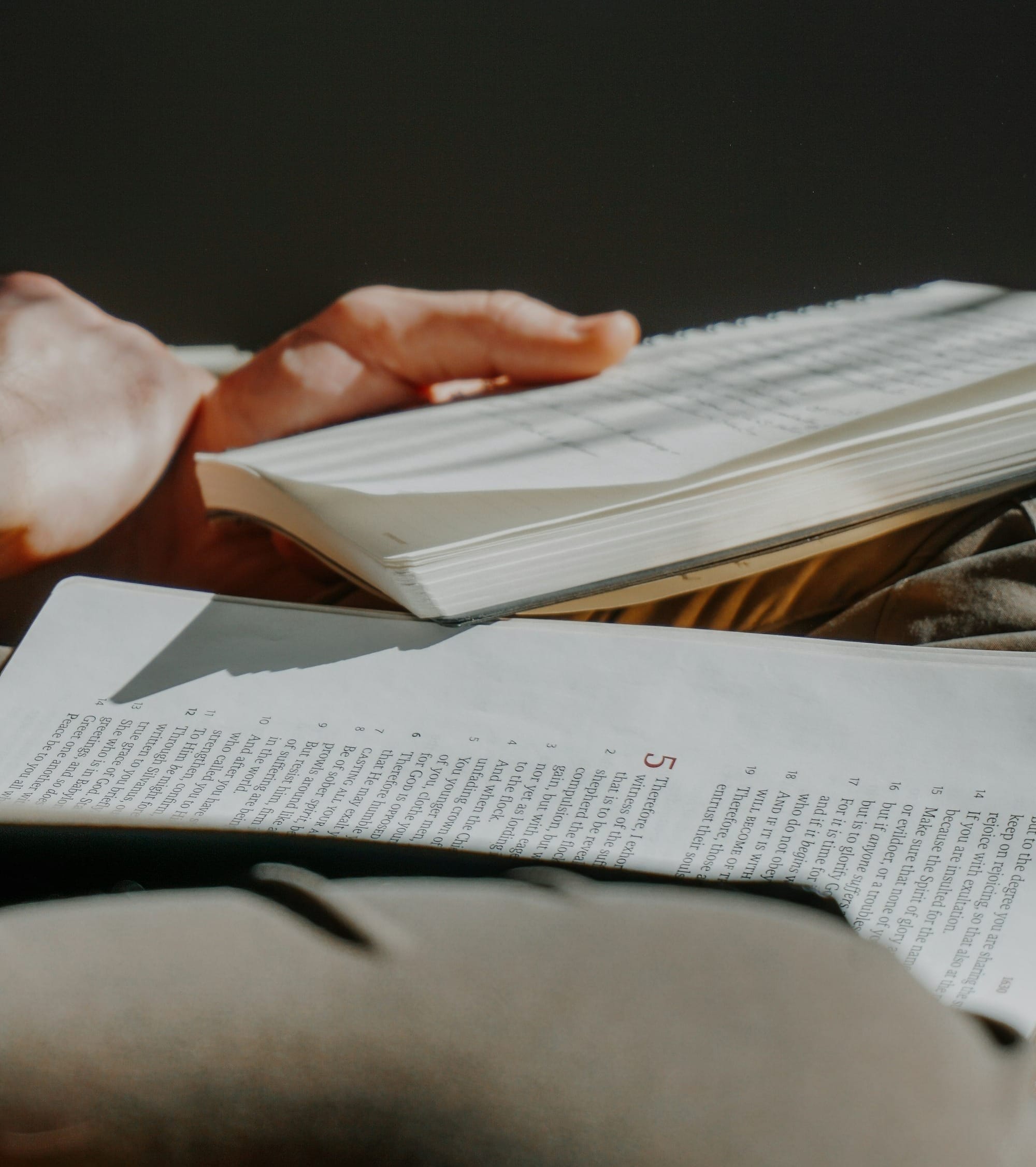 A person reading a book with pages open.