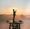 A man standing on a wooden platform praying to God.
