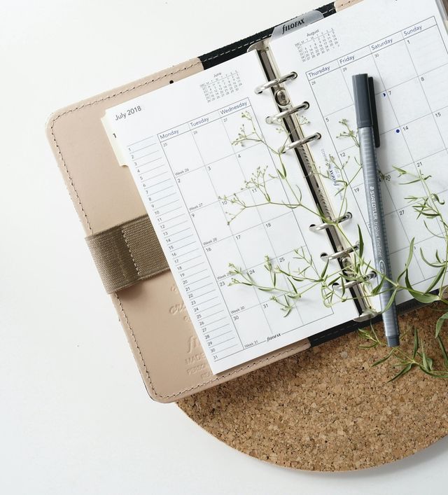 A person reviewing a planner to plan their time and finances showing accountability. 