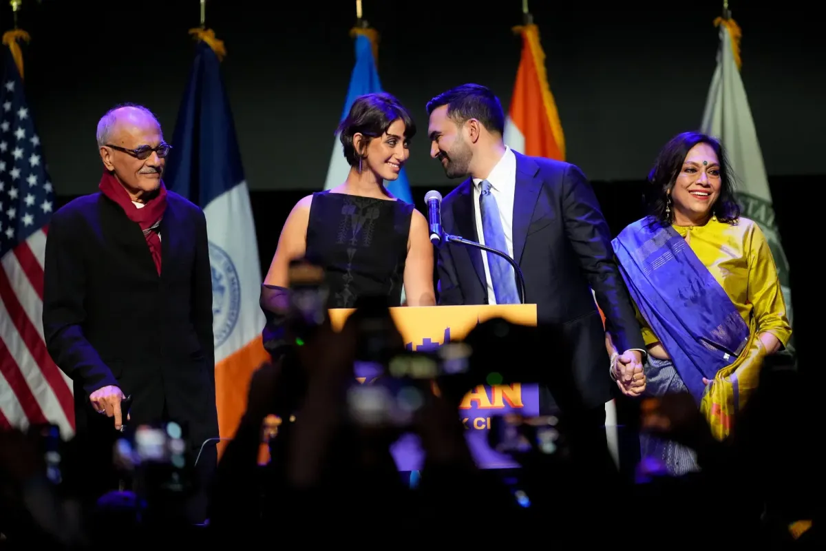 New York City's Mayor-Elect Zohran Mamdani celebrates with his wife Rama Duwaji and parents on stage on election night.