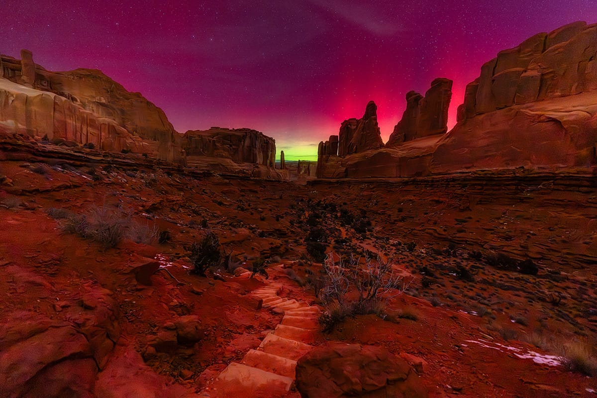 Aurora borealis glowing above the sandstone cliffs of Park Avenue in Arches National Park, Utah, in January 2026.