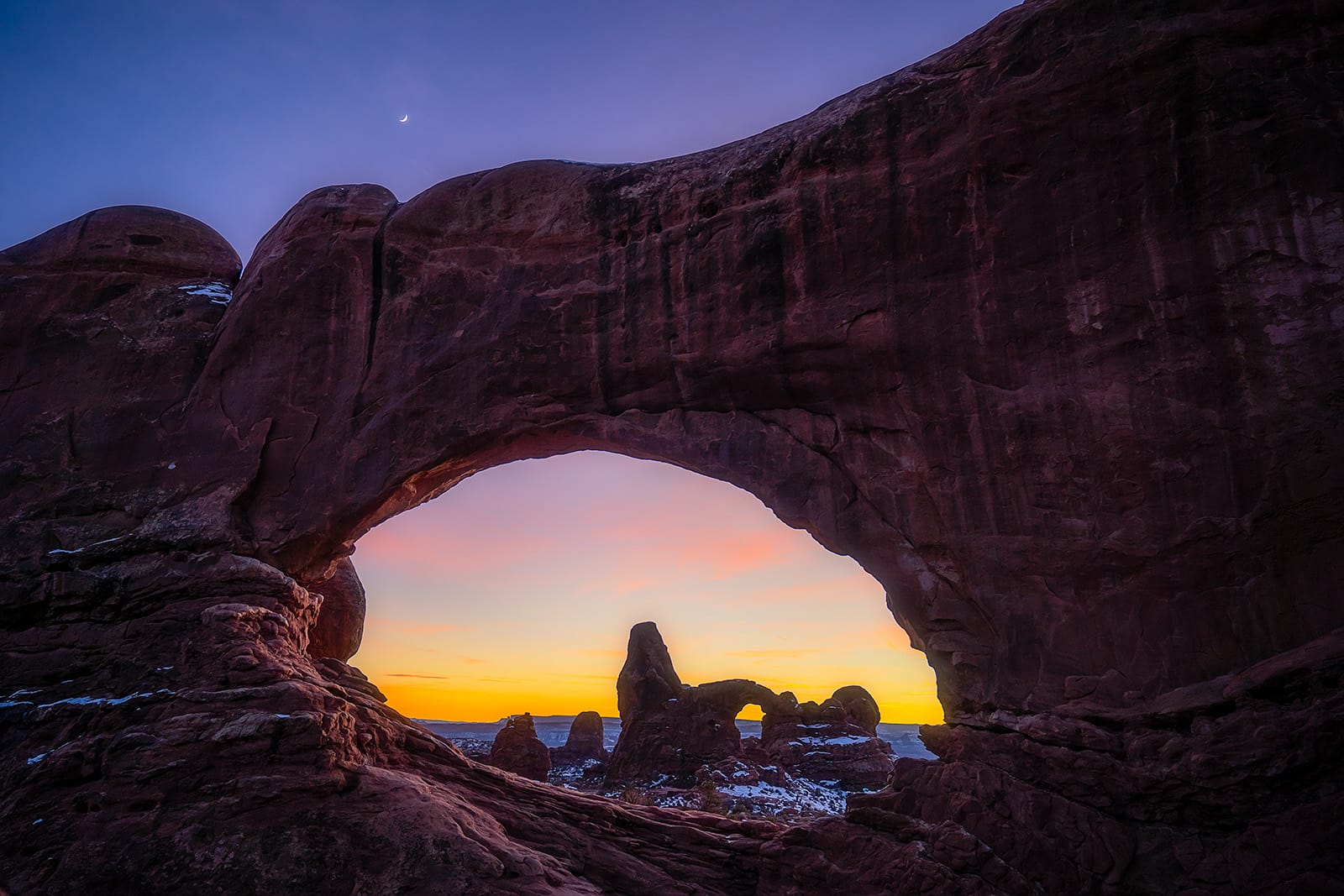 Sunset through North Windows Arch looking towards Turret Arch in Arches National Park. © Roaming the Southwest