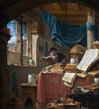 A man stands at a writing desk, a folio book in his hands. In front of him, the desk is piled high with books, and a globe. Light from the window on his light streams into the study