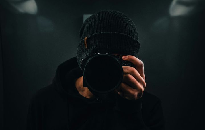 A Man holding a camera facing the reader