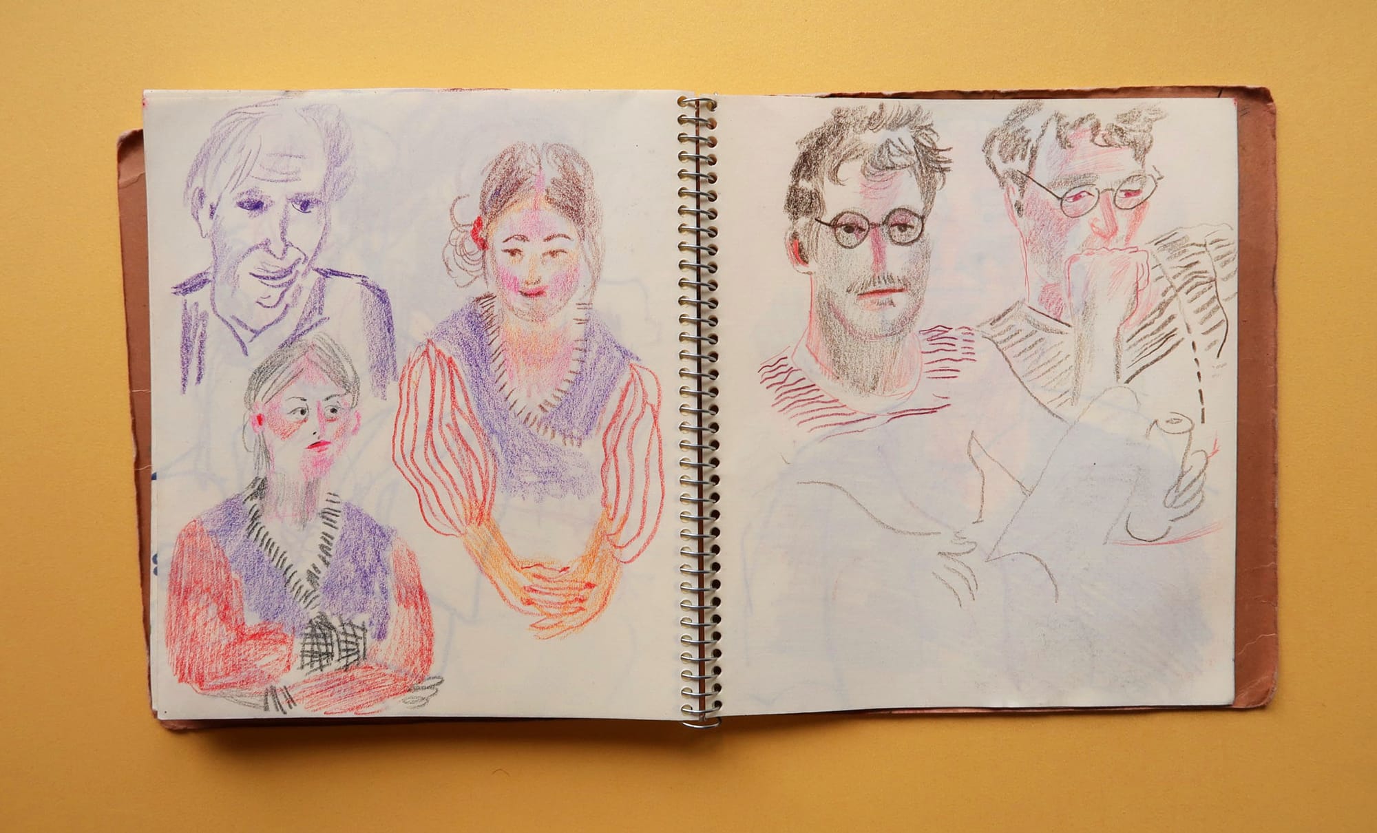 Double spread spiral sketchhbook compiling colour pencil portraits.