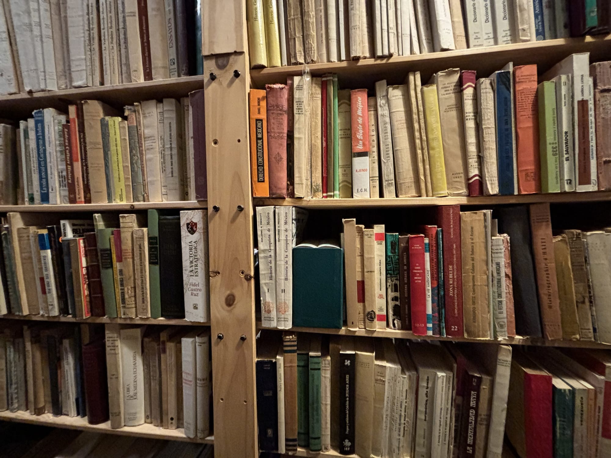 Wooden shelves filled with Spanish-language books at Torreón de Rueda.