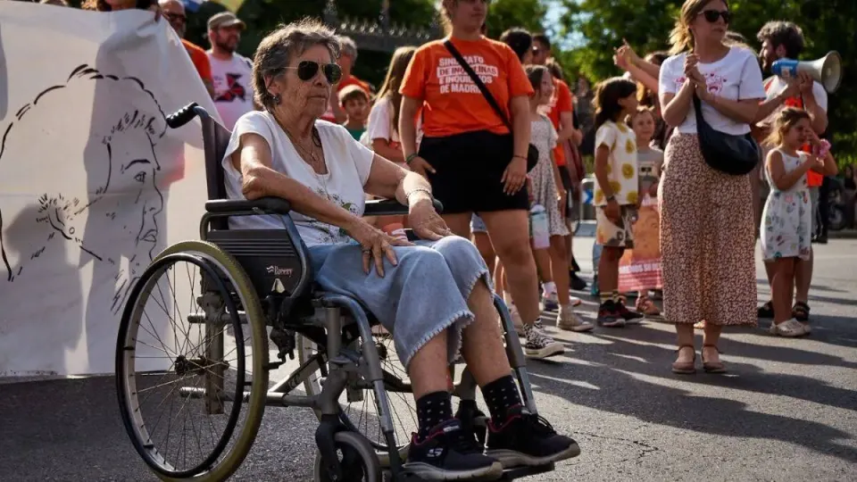 Maricarmen seated in her wheelchair beside a portrait of her at a housing protest in Madrid. Photo: Sindicato de Inquilinas de Madrid / CC BY-SA 4.0.