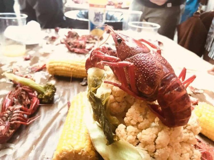 table with whole prawns, corn and vegetables.