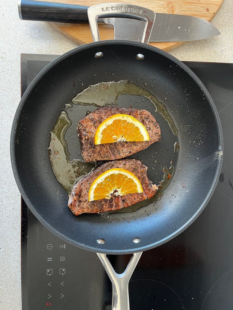 Sauteé tuna steak in a frying pan on an induction stove.