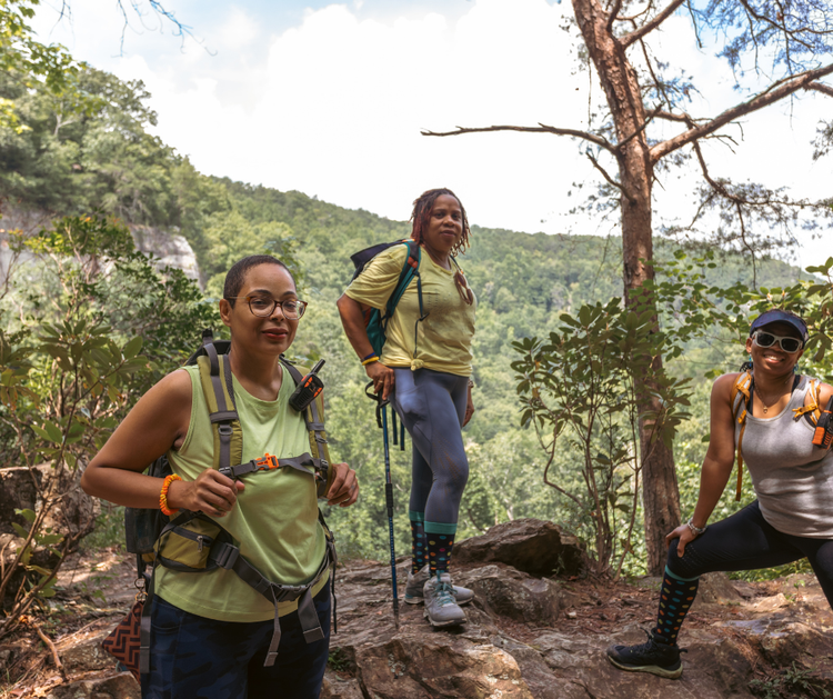 Three women hiking in a mountain forest.