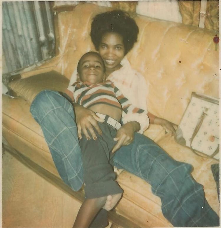 Young handsome boy and his beatiful mother posing on a sofa in an embrace.