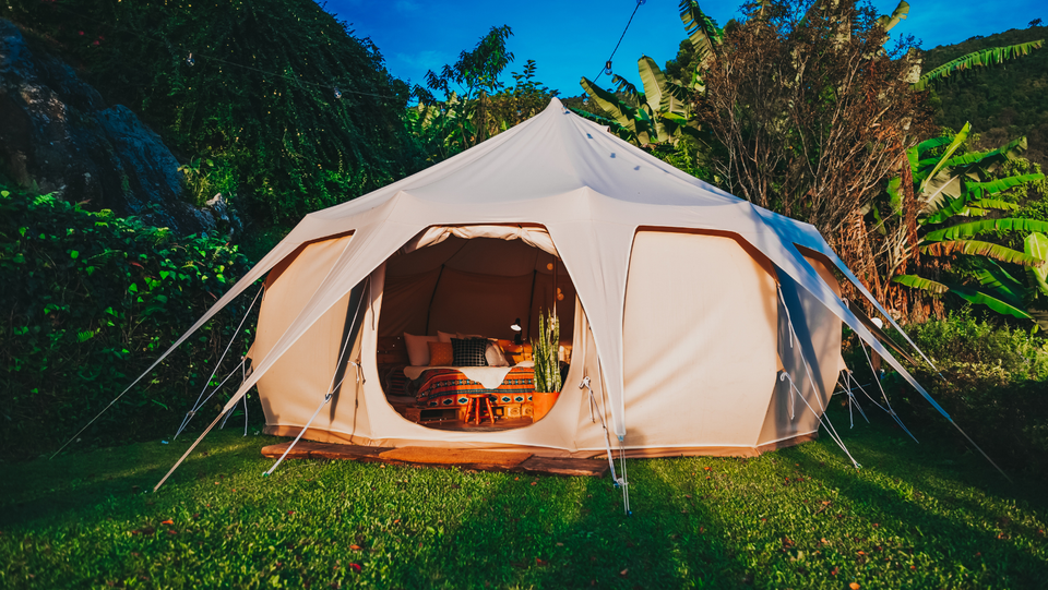 Glamping tent in a green garden.