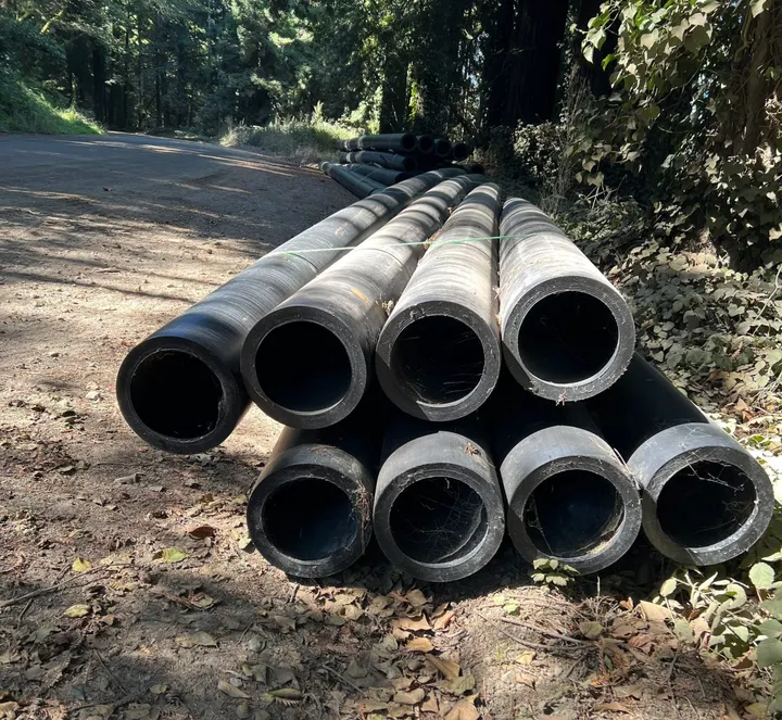 A long section of 10-inch-diameter water pipe lying on the ground near the excavated site of a break in Fort Bragg's raw water line..