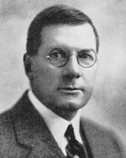 Vintage portrait of a man with glasses in a suit.
