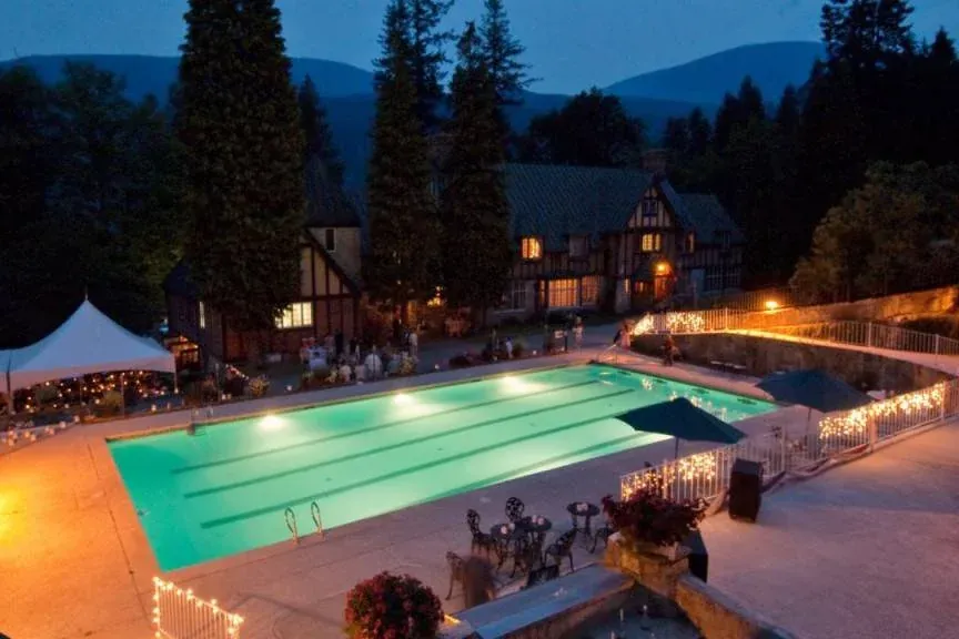 Blaylock Mansion pool area illuminated at night with surrounding trees.