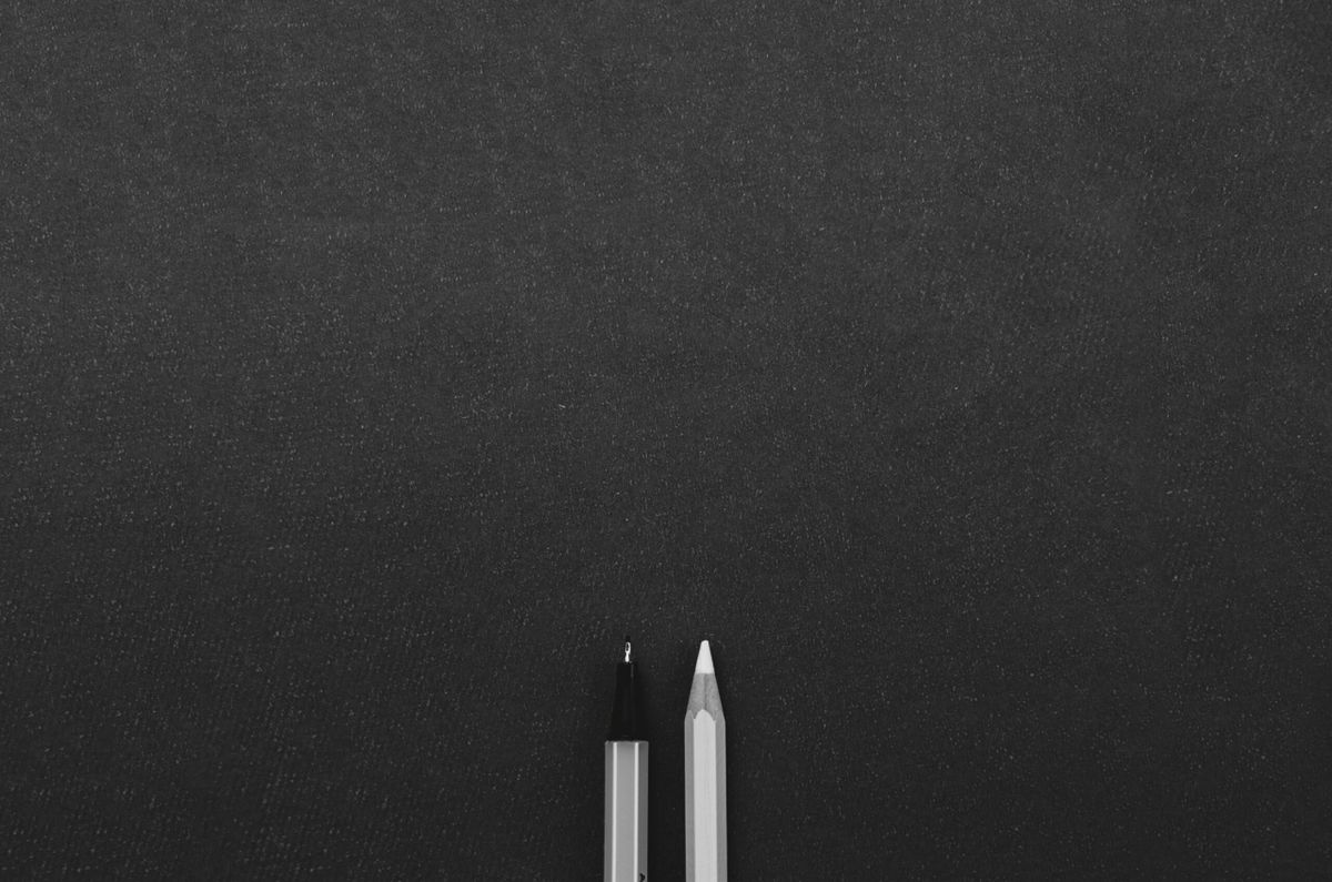 Writing tools on a blank black background.