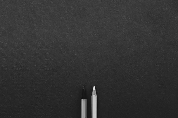 Writing tools on a blank black background.