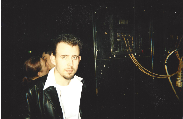 The author snapped in a nightclub, looking dismayed as a couple make out in the background.