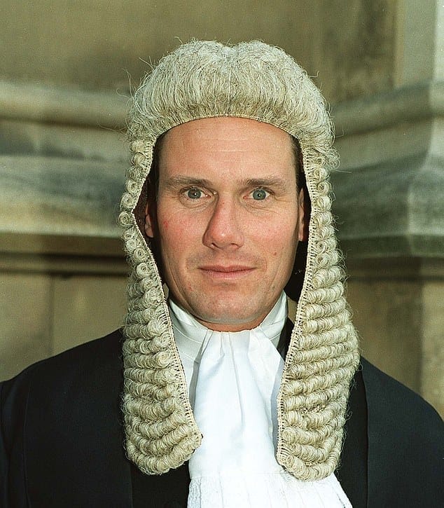 Sir Keir Starmer dressed ridiculously as a prosecutor, with soulless eyes.