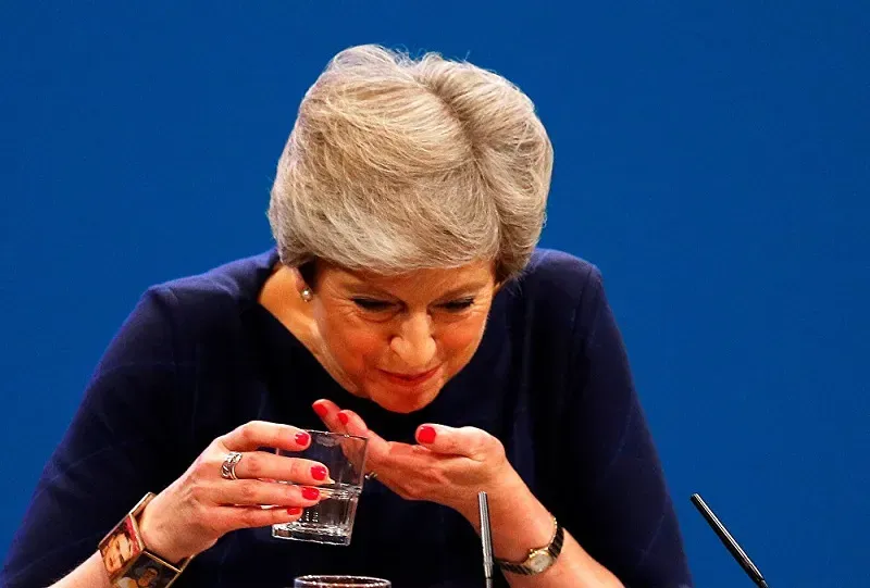 Theresa May chokes on her own words as she wears a Frida Kahlo bracelet for her speech at the Tory conference.