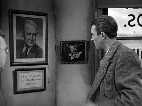 Screenshot from It's a Wonderful Life, with George Bailey (James Stewart) looking at a portrait of his late father over framed text: "All you can take with you is that which you've given away."