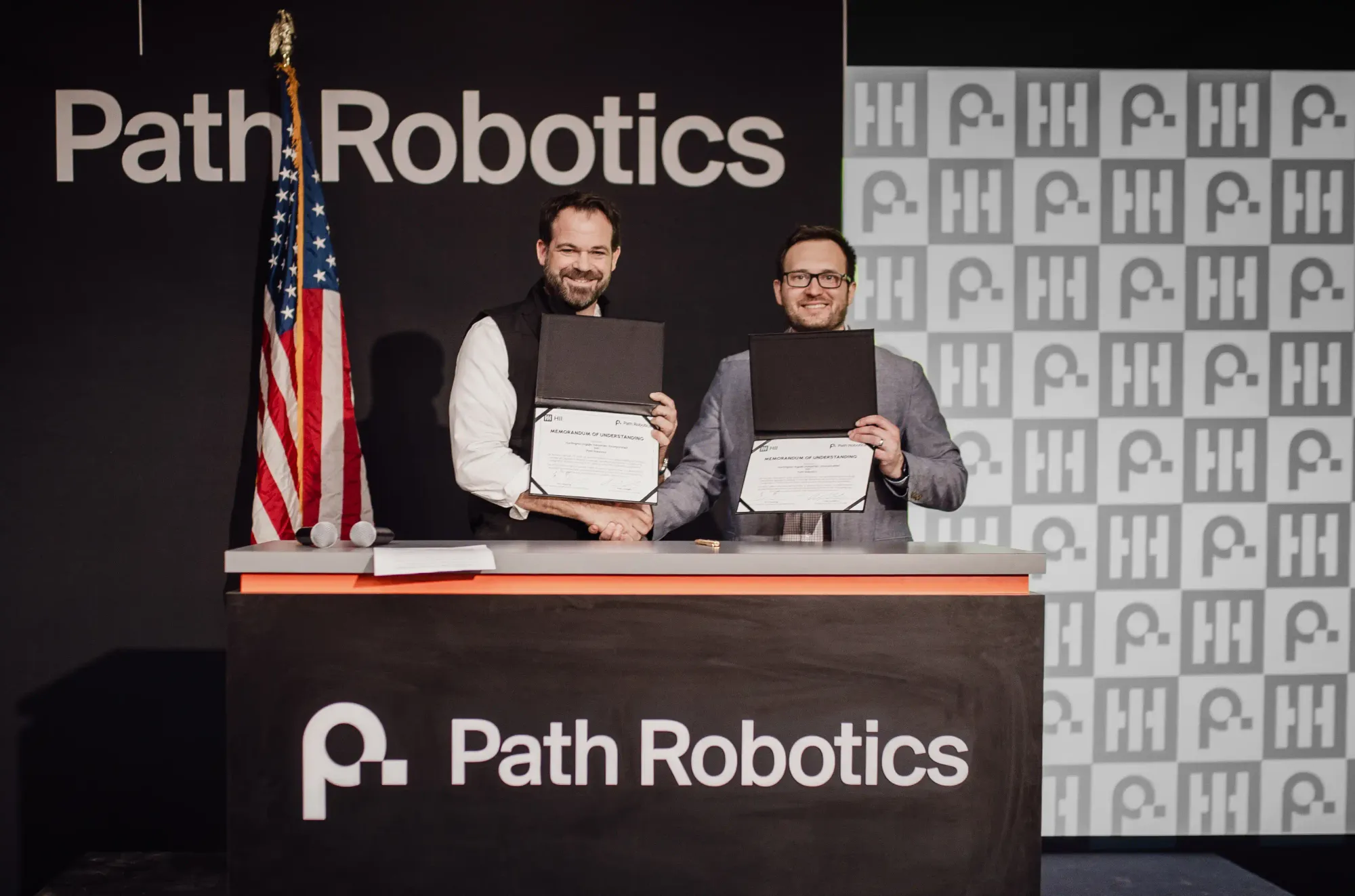 Eric Chewning (Left), HII’s executive vice president of maritime systems & corporate strategy, and Andy Lonsberry (right), CEO and co-founder, Path Robotics signed a memorandum. Credt: HII