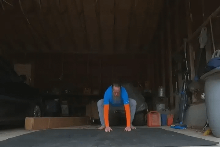 A man doing bodyweight exercises in a garage.
