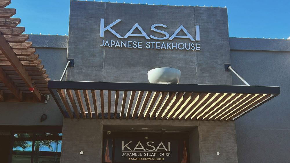 of a flat iron teppanyaki griddle surface with steam rising, warm amber kitchen light, no people, no text
