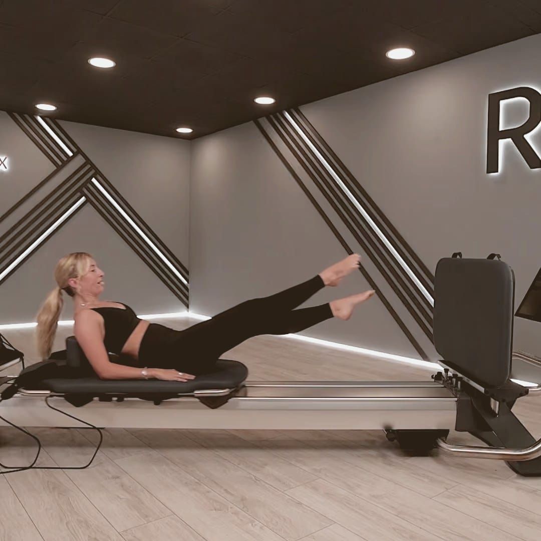 of a modern Pilates reformer carriage rail in a clean, minimalist studio setting, no people, warm natural light